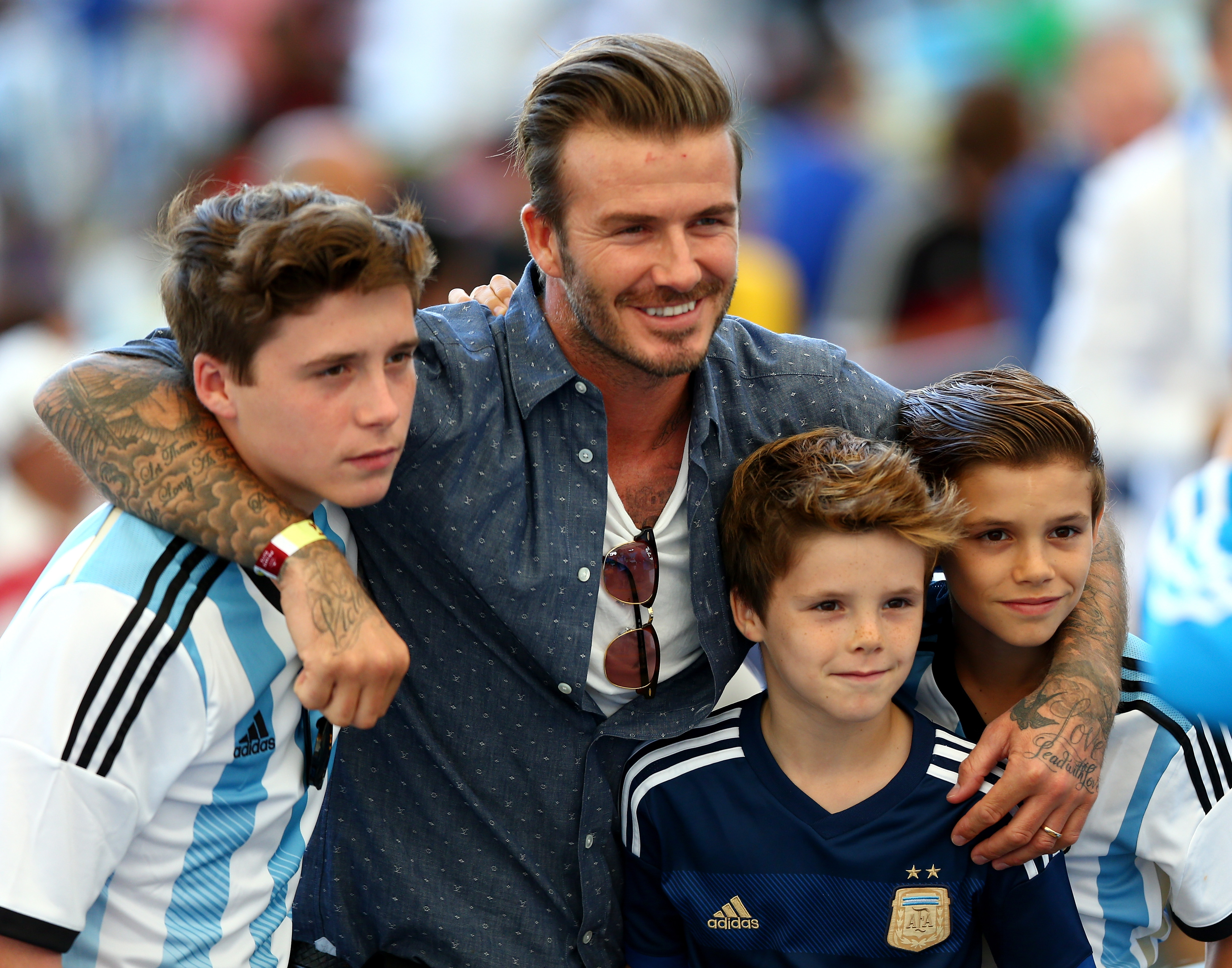 Former England international David Beckham and sons Brooklyn Beckham (L), C...