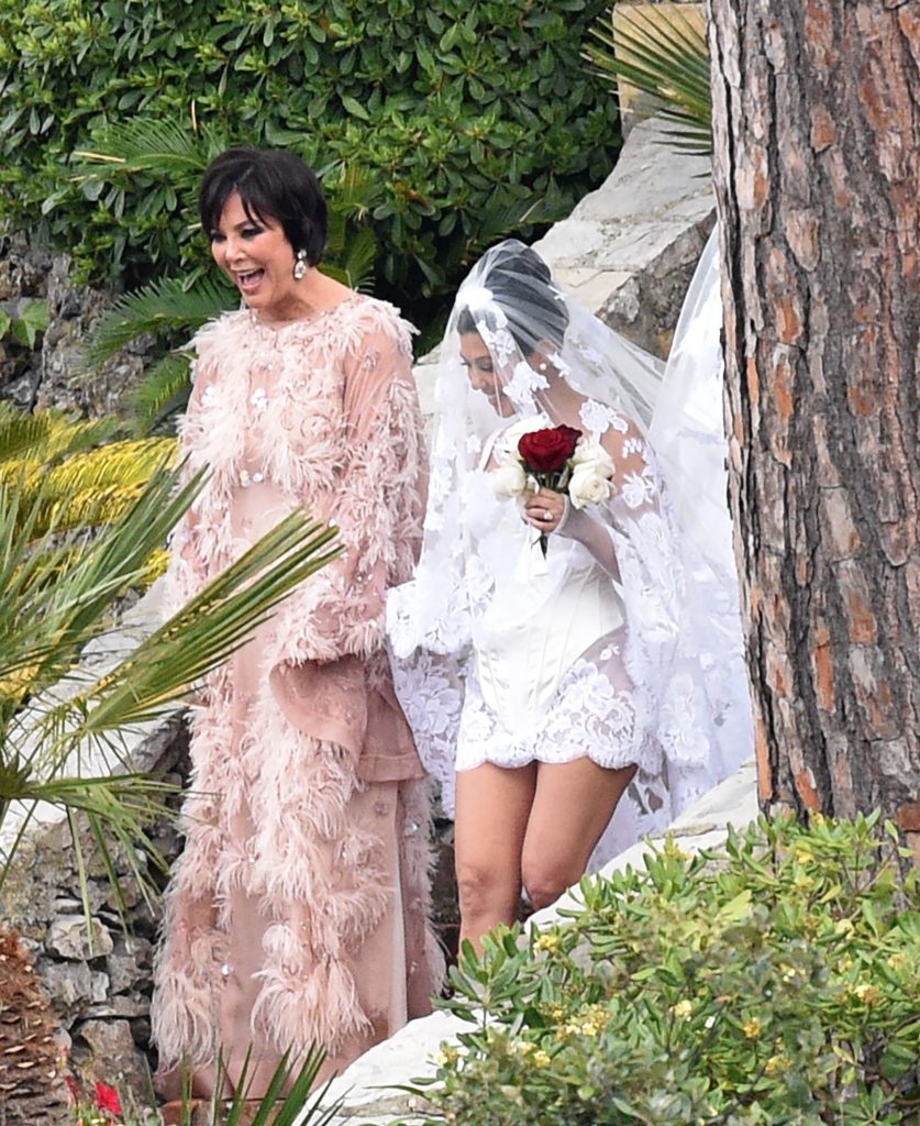 Kourtney Kardashian is seen being guided to her wedding by mother Kris