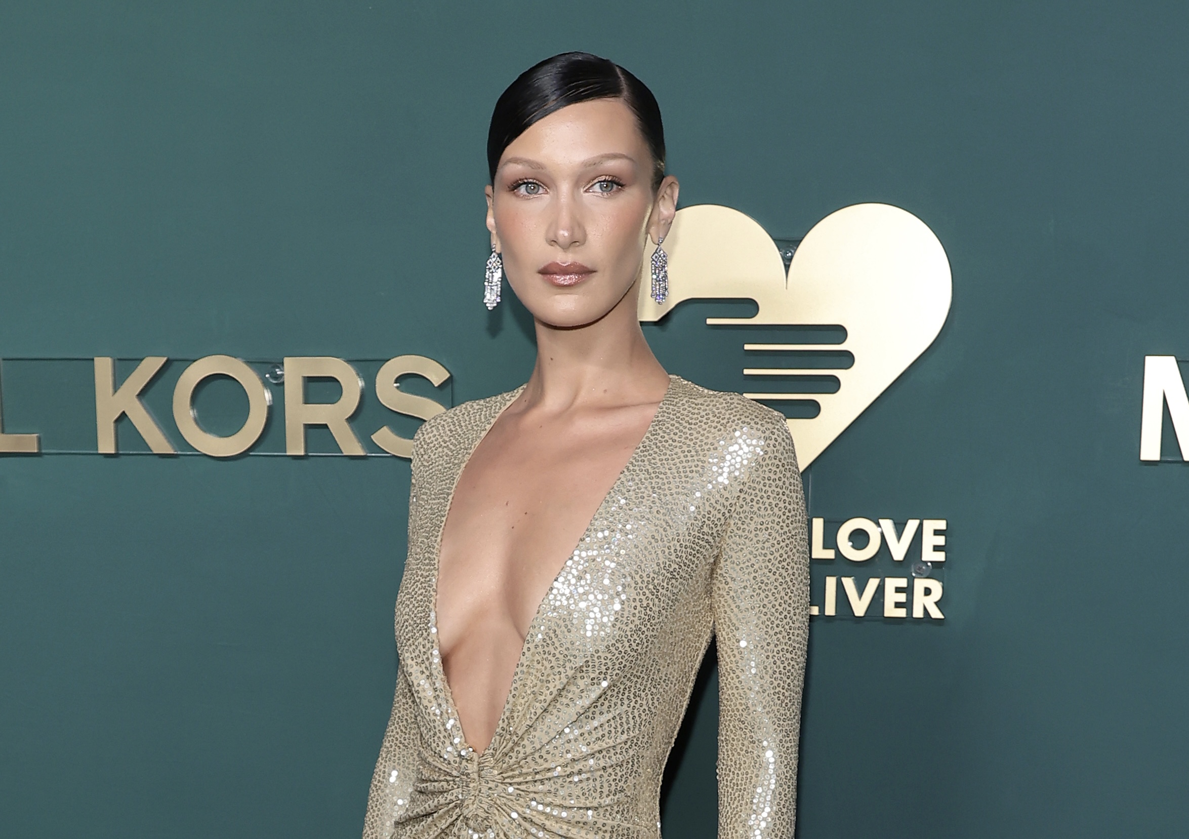 All shimmering gold: Bella Hadid popped up in a huge neckline dress